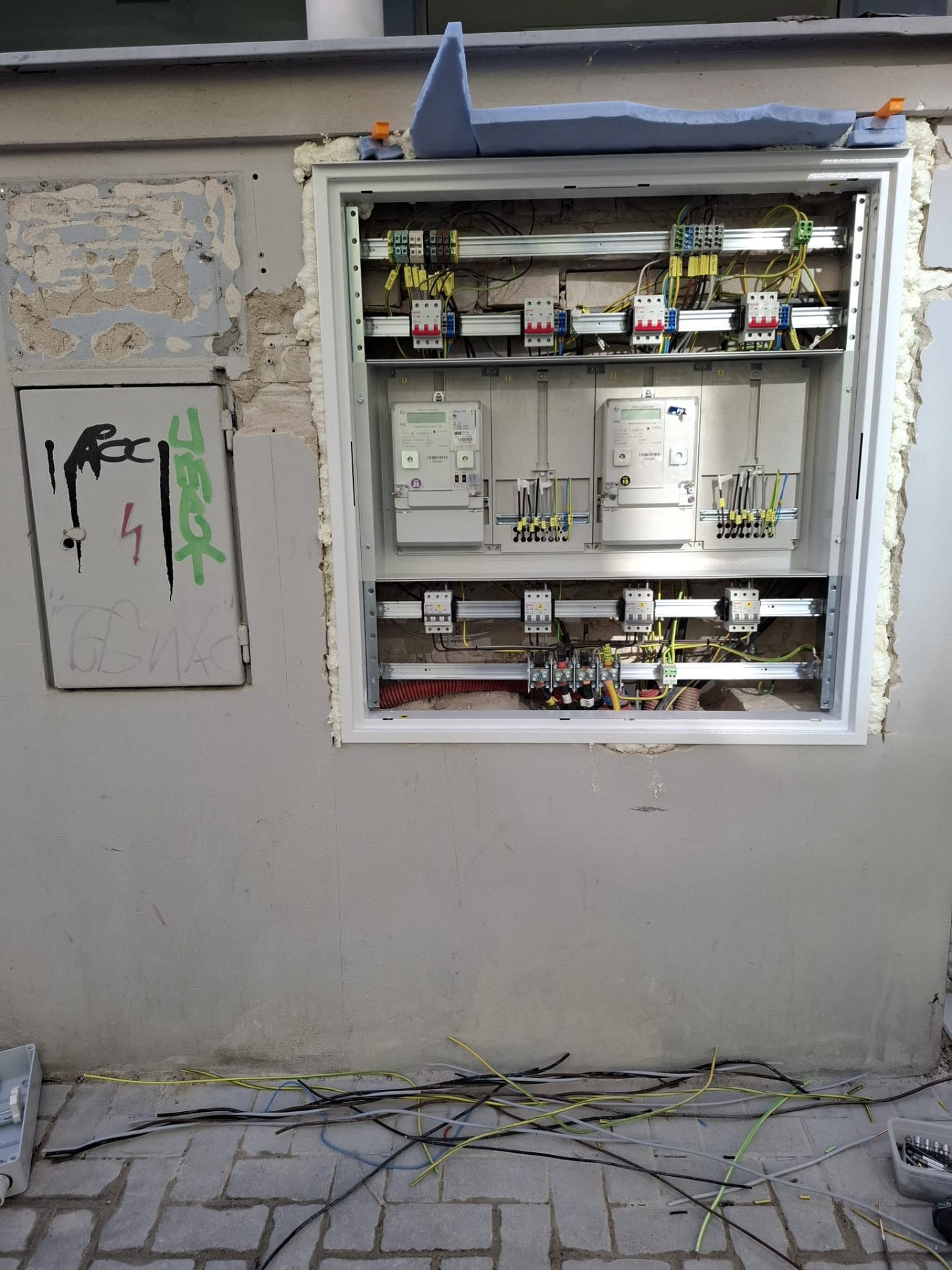 Skříň domovních stoupaček s elektroměry na fasádě